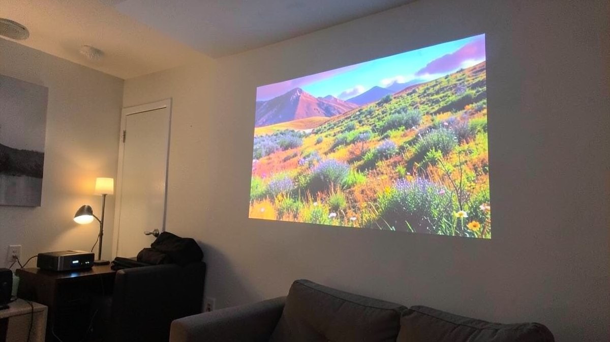 Combien de lumens pour un vidéoprojecteur : un projecteur affiche une image lumineuse dans un salon éclairé