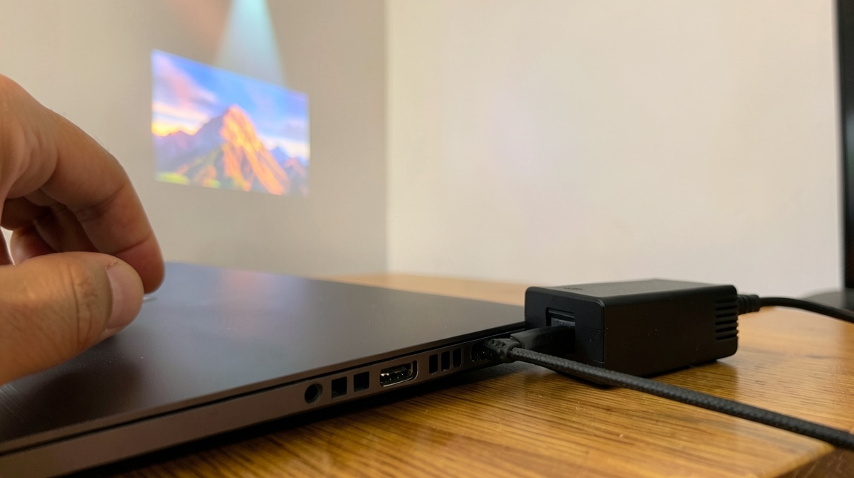 DisplayPort Alt Mode : câble USB-C tressé branché sur le port d'un ordinateur portable, image projetée au mur en arrière-plan